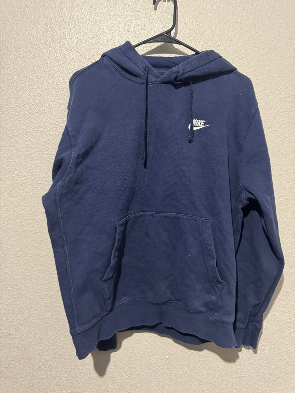 Navy blue Nike pullover hoodie, featuring a white embroidered Nike Logo
